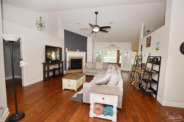 living room with a tile fireplace, lofted ceiling, dark hardwood / wood-style floors, and ceiling fan