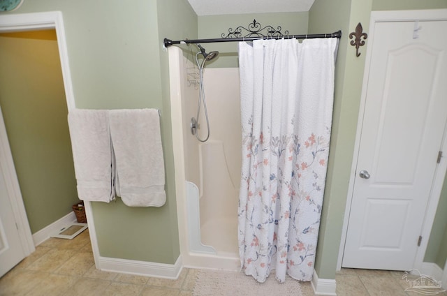 bathroom with a shower with shower curtain and tile patterned floors