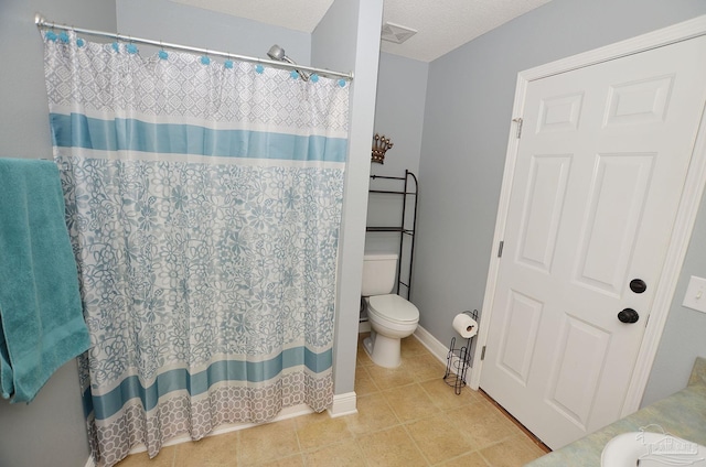 bathroom featuring a shower with shower curtain, a textured ceiling, tile patterned floors, and toilet