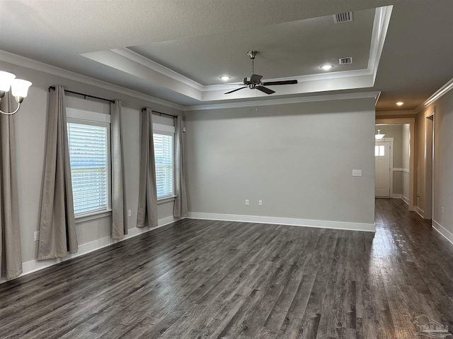 unfurnished room with ceiling fan, a tray ceiling, dark hardwood / wood-style flooring, and crown molding