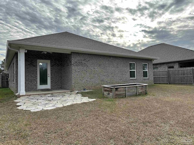 back of property with a lawn and a patio area