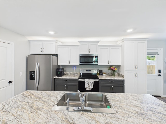 430 Morris Ave, Cantonment, FL 32533 - kitchen with appliances with stainless steel finishes, a sink, white cabinetry, recessed lighting, and light stone countertops
