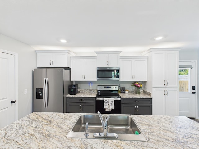 430 Morris Ave, Cantonment, FL 32533 - kitchen with stainless steel appliances, a sink, white cabinets, recessed lighting, and light stone counters