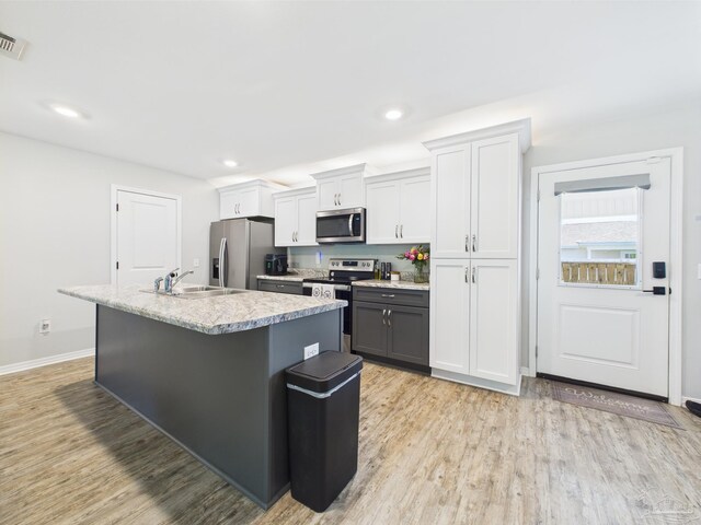 430 Morris Ave, Cantonment, FL 32533 - kitchen with appliances with stainless steel finishes, a sink, a center island with sink, light wood-style floors, and recessed lighting