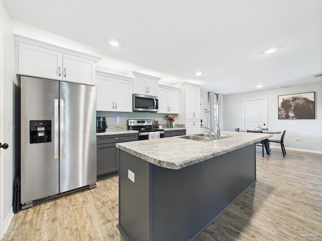 430 Morris Ave, Cantonment, FL 32533 - kitchen featuring appliances with stainless steel finishes, a sink, baseboards, a kitchen island with sink, and light wood finished floors