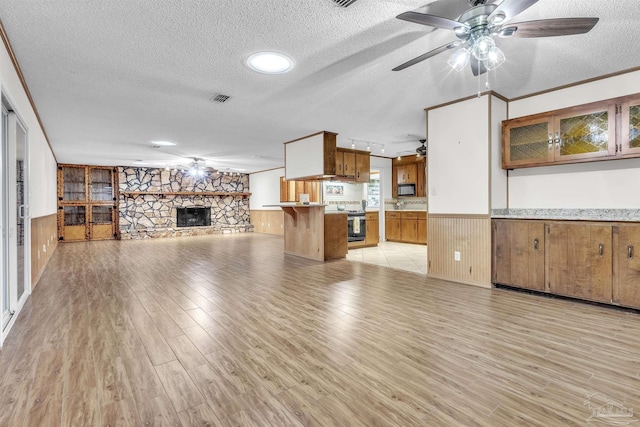 465 Man O War Cir, Cantonment, FL 32533 - unfurnished living room featuring a textured ceiling, light wood finished floors, wainscoting, wooden walls, and ceiling fan