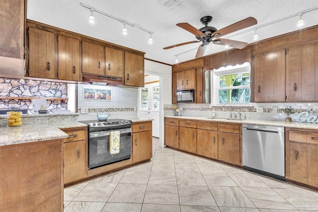 465 Man O War Cir, Cantonment, FL 32533 - kitchen with appliances with stainless steel finishes, under cabinet range hood, backsplash, a textured ceiling, and track lighting