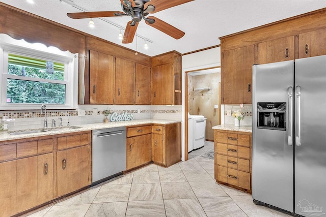 465 Man O War Cir, Cantonment, FL 32533 - kitchen featuring appliances with stainless steel finishes, backsplash, brown cabinetry, ceiling fan, and washer / dryer