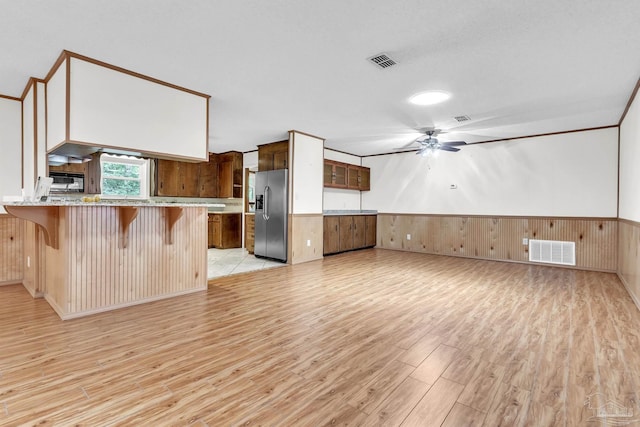 465 Man O War Cir, Cantonment, FL 32533 - kitchen featuring stainless steel fridge, light wood-style floors, a breakfast bar area, a ceiling fan, and a wainscoted wall