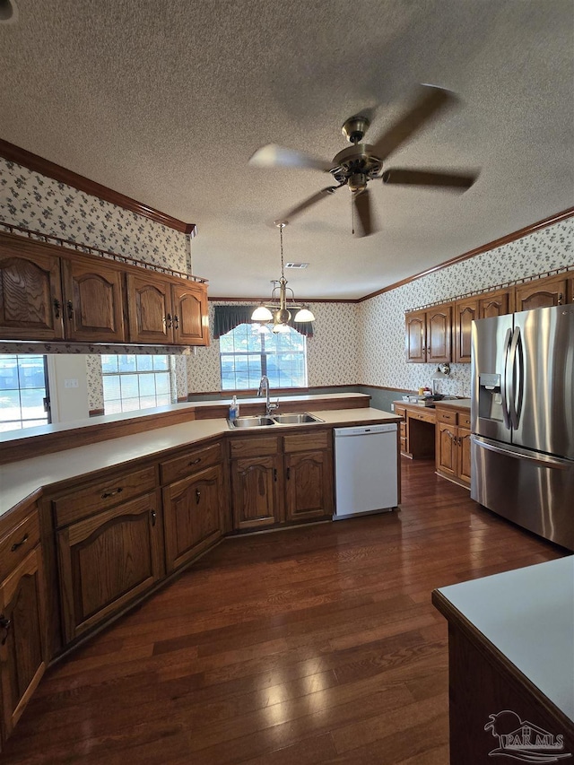 kitchen with stainless steel refrigerator with ice dispenser, sink, crown molding, hanging light fixtures, and white dishwasher