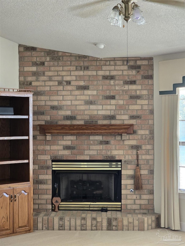 room details featuring ceiling fan, a fireplace, and a textured ceiling