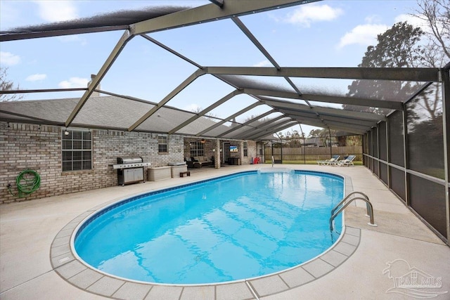 outdoor pool with a lanai, a grill, a patio, and area for grilling