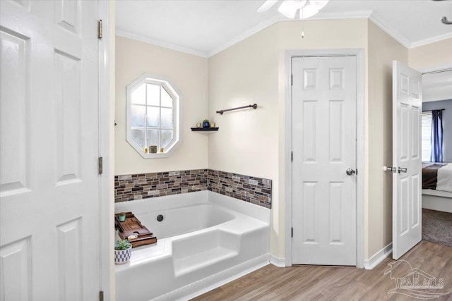 ensuite bathroom with crown molding, plenty of natural light, connected bathroom, and wood finished floors