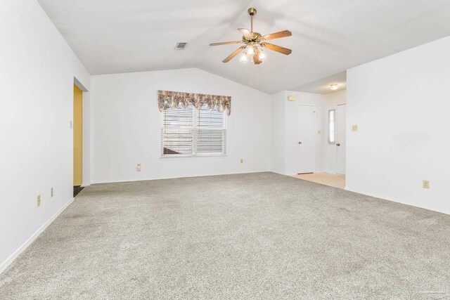 spare room featuring a textured ceiling, ceiling fan, light carpet, and vaulted ceiling