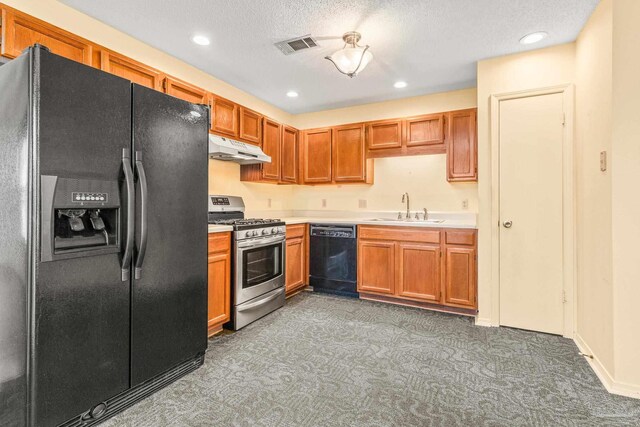 kitchen with black appliances, a textured ceiling, dark colored carpet, and sink