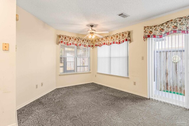 carpeted spare room with a textured ceiling and ceiling fan