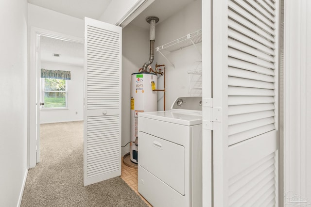 laundry area with light carpet, water heater, and washer / clothes dryer