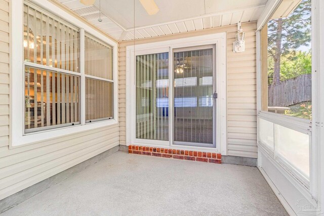 unfurnished sunroom featuring a healthy amount of sunlight and ceiling fan