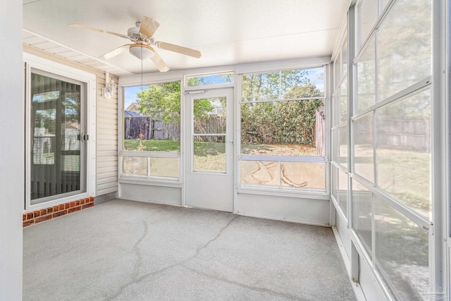 unfurnished sunroom featuring ceiling fan