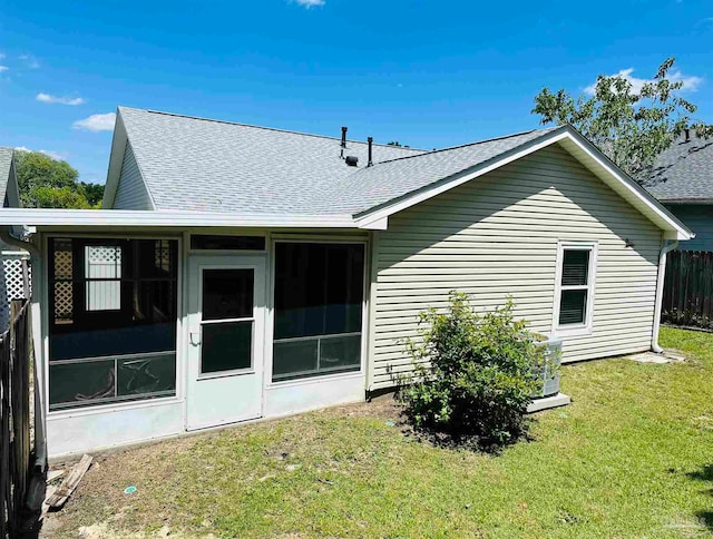 back of house featuring a sunroom and a yard