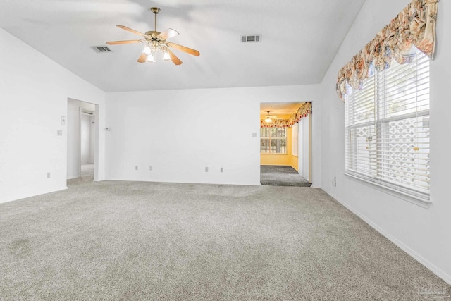 carpeted empty room with ceiling fan with notable chandelier and vaulted ceiling