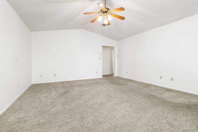 carpeted spare room with lofted ceiling, ceiling fan, and a textured ceiling