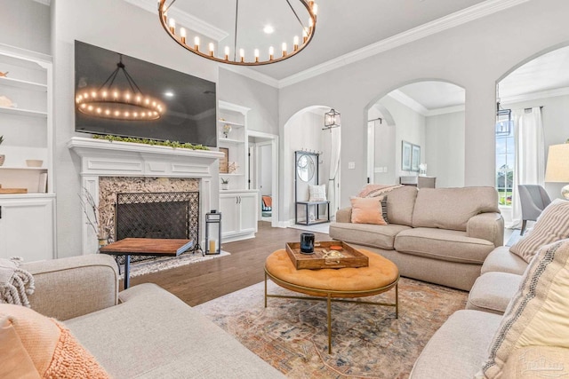 2120 Eagles Ridge Cv, Cantonment, FL 32533 - living area with arched walkways, built in features, a chandelier, wood finished floors, and crown molding