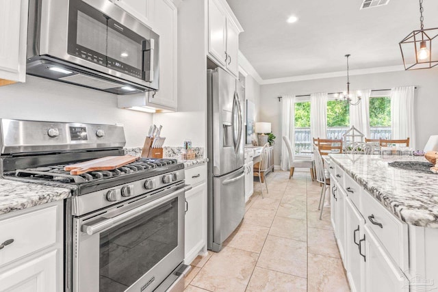 2120 Eagles Ridge Cv, Cantonment, FL 32533 - kitchen featuring appliances with stainless steel finishes, ornamental molding, a chandelier, white cabinets, and pendant lighting