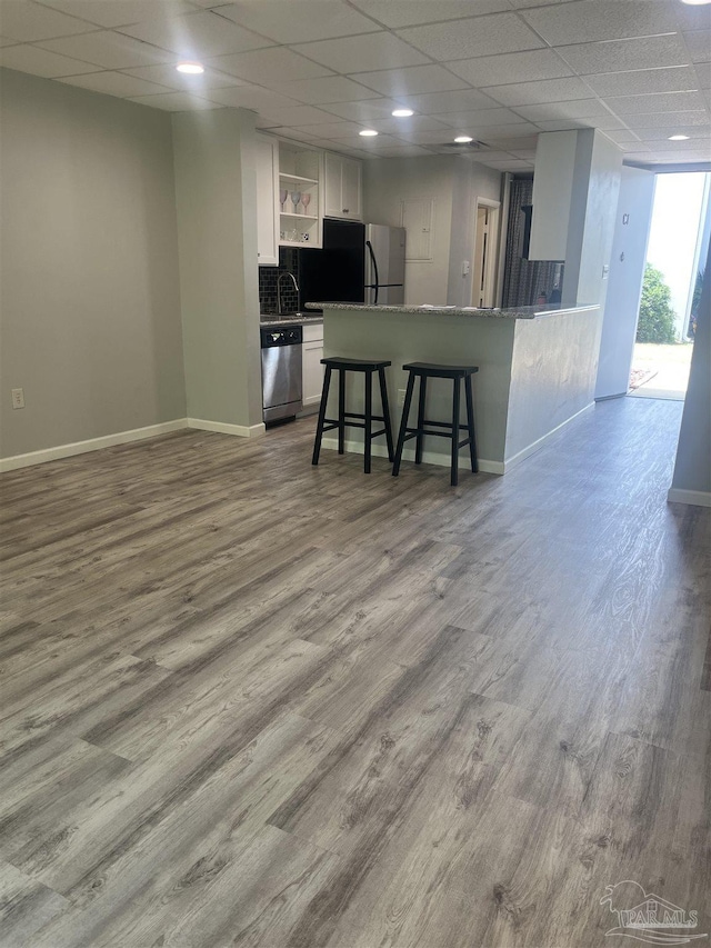 201 Pensacola Beach Rd Unit C1, Gulf Breeze, FL 32561 - kitchen featuring open shelves, wood finished floors, baseboards, white cabinetry, and appliances with stainless steel finishes
