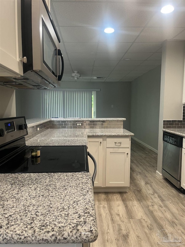 201 Pensacola Beach Rd Unit C1, Gulf Breeze, FL 32561 - kitchen featuring decorative backsplash, recessed lighting, white cabinetry, light stone counters, and stainless steel appliances