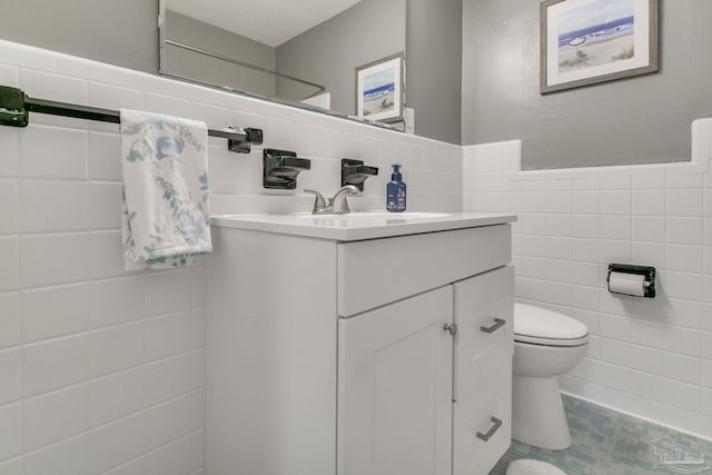 bathroom featuring tile walls, vanity, and toilet