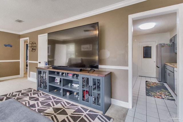 living room featuring ornamental molding, light tile patterned floors, and a textured ceiling