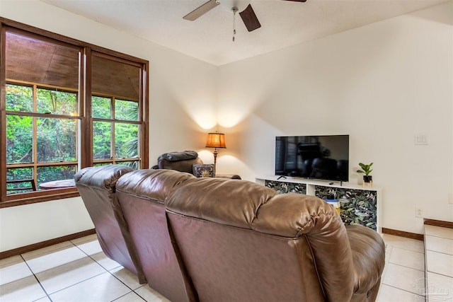living room featuring baseboards, light tile patterned flooring, and ceiling fan