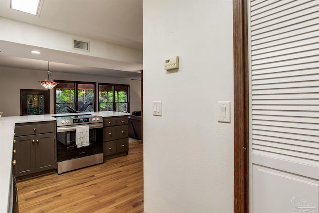 kitchen with recessed lighting, light countertops, stainless steel electric range oven, light wood-style floors, and visible vents