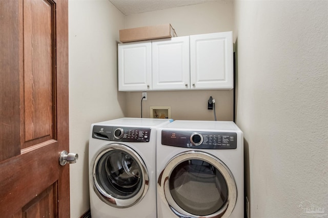 laundry room with washing machine and dryer and cabinet space