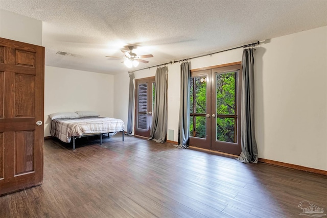 bedroom with visible vents, baseboards, ceiling fan, a textured ceiling, and wood finished floors