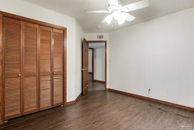 unfurnished bedroom featuring visible vents, baseboards, a closet, and wood finished floors