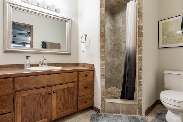 full bathroom with vanity, baseboards, a stall shower, tile patterned flooring, and toilet
