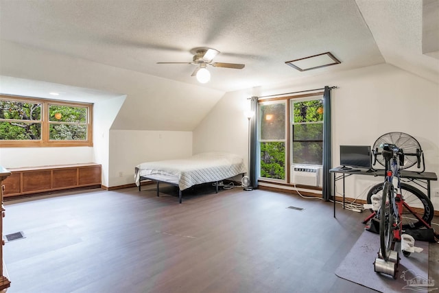 bedroom featuring visible vents, a textured ceiling, wood finished floors, and lofted ceiling