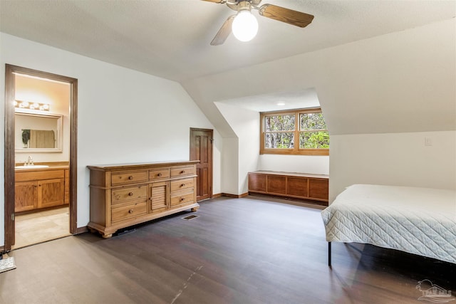 bedroom featuring ensuite bathroom, a ceiling fan, lofted ceiling, a sink, and wood finished floors