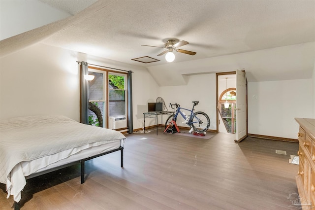bedroom featuring a textured ceiling, wood finished floors, baseboards, and a ceiling fan