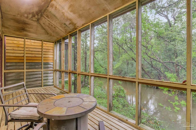 sunroom featuring a water view