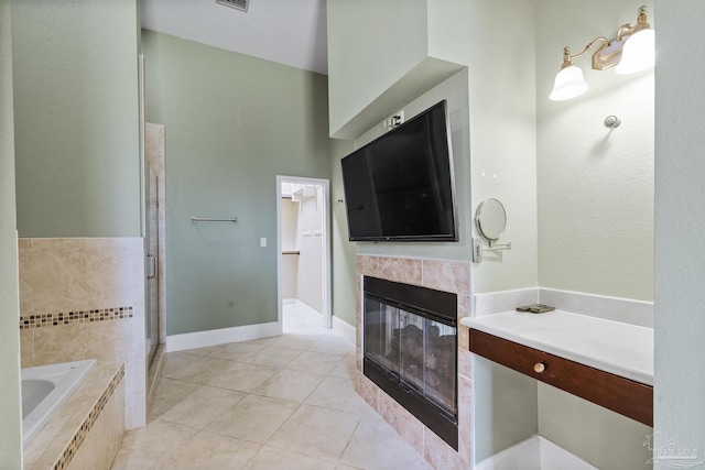 bathroom featuring tile patterned flooring, shower with separate bathtub, and a tiled fireplace