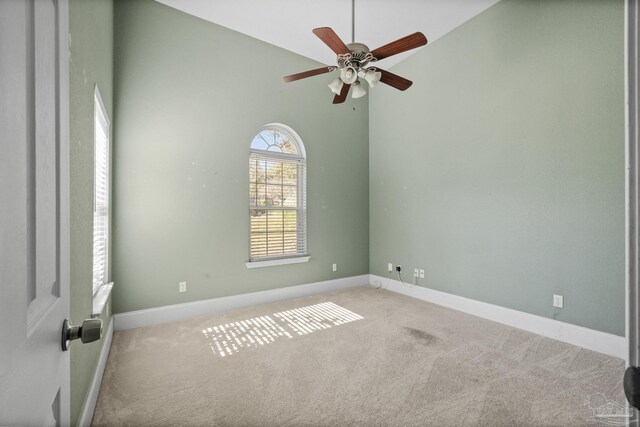 carpeted spare room with high vaulted ceiling and ceiling fan