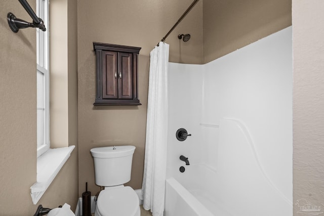 bathroom featuring toilet and shower / tub combo with curtain