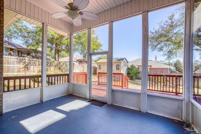 unfurnished sunroom with ceiling fan