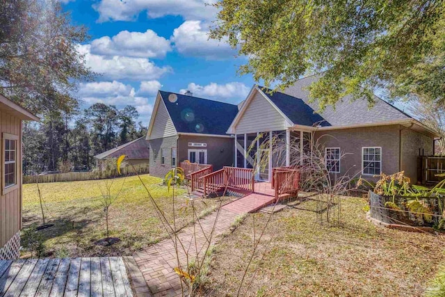 rear view of property with a lawn and a deck