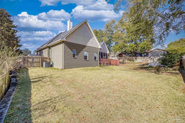 back of property featuring a lawn and central air condition unit