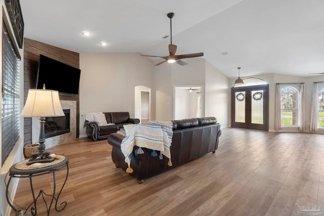 420 Palm Lake Dr, Pensacola, FL 32507 - living room featuring a ceiling fan, vaulted ceiling, light wood-type flooring, a large fireplace, and arched walkways