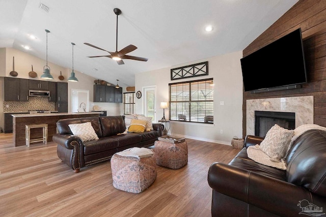 420 Palm Lake Dr, Pensacola, FL 32507 - living area with ceiling fan, vaulted ceiling, light wood finished floors, a fireplace, and baseboards